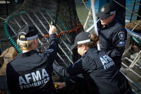 Three AFMA Compliance Officers inspect a fishing net